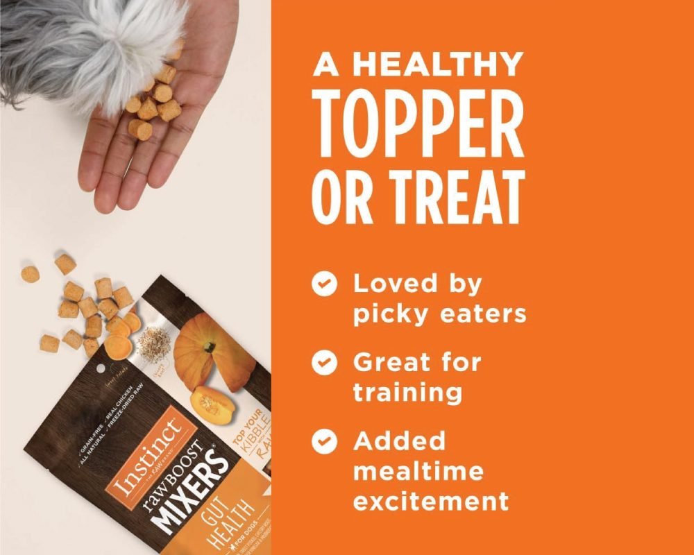 A close-up of a dog's furry paw and a human hand holding small, light-colored dog treats. Below, a bag of "Instinct Raw Boost Mixers Gut Health" dog food topper with chicken and pumpkin, next to an orange background with text highlighting benefits like "A HEALTHY TOPPER OR TREAT," "Loved by picky eaters," "Great for training," and "Added mealtime excitement."